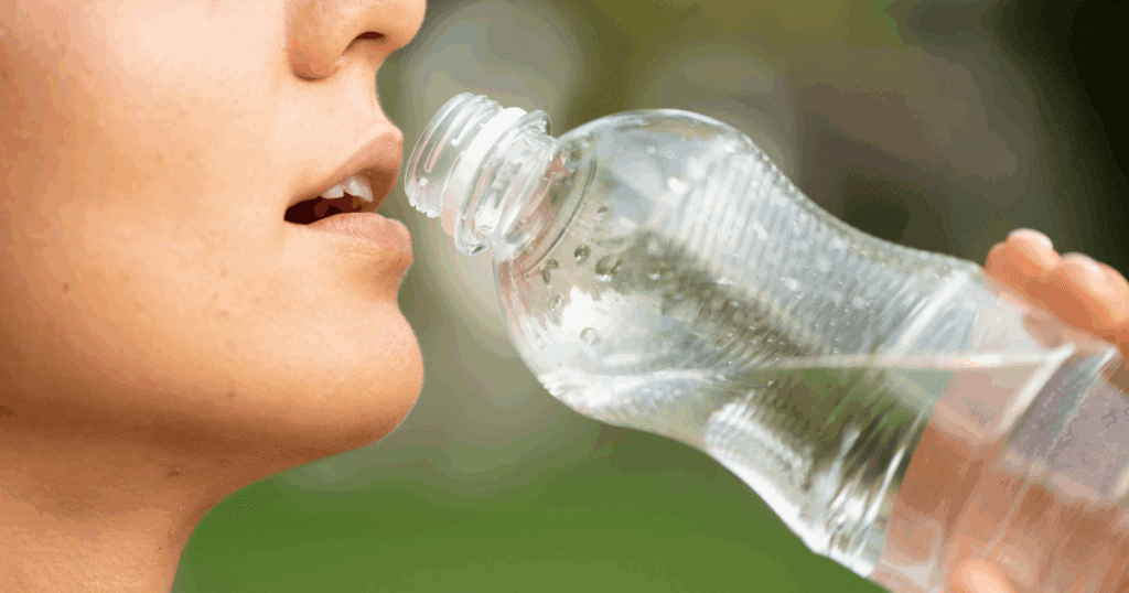 Bottles of mineral and sparkling water placed against a sunny Dubai backdrop, available for delivery via Grubss