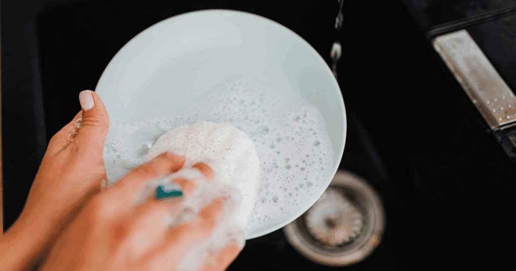 Powder and liquid dishwashing detergents placed near a dishwasher in a modern Dubai kitchen