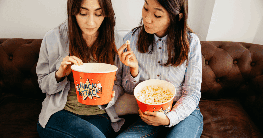 Movie night snack board with popcorn, chips, nuts, and dips in a cozy Dubai home setup